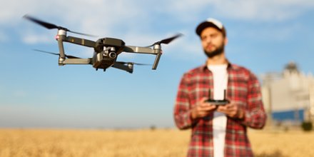 Landwirt steuert Drohne über reifes Kornfeld.