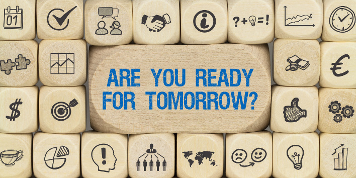 Würfel mit Schriftzug "Are you ready for tomorrow?" umgeben von anderen Würfeln mit unternehmerischen Icons.