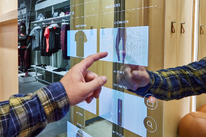 Kunde bedient eine digitale Umkleidekabine im Future Store eines großen Sportgeschaefts in Berlin